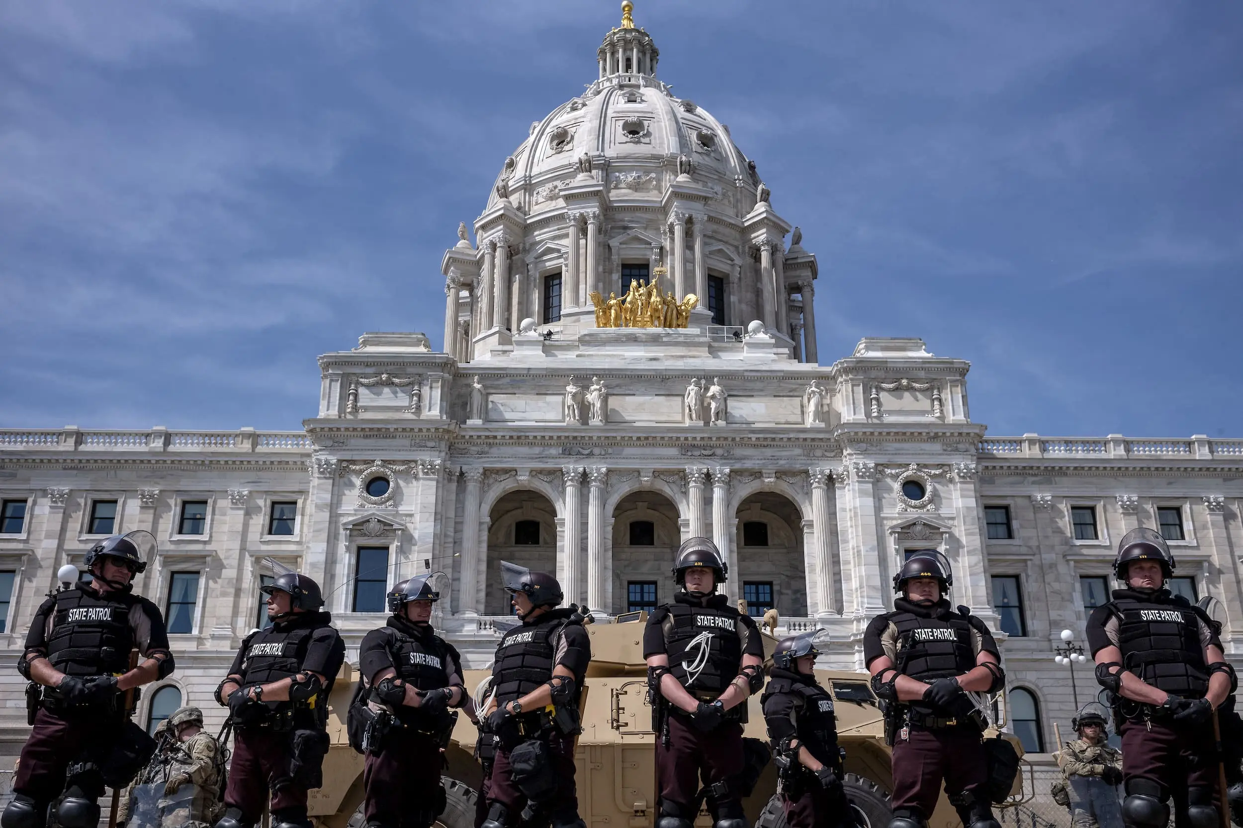 In the aftermath of the police killing of George Floyd, Minnesota State Police officers are backed by Minnesota National Guardmembers and armored personnel carriers in front of the state house on May 31, 2020.
