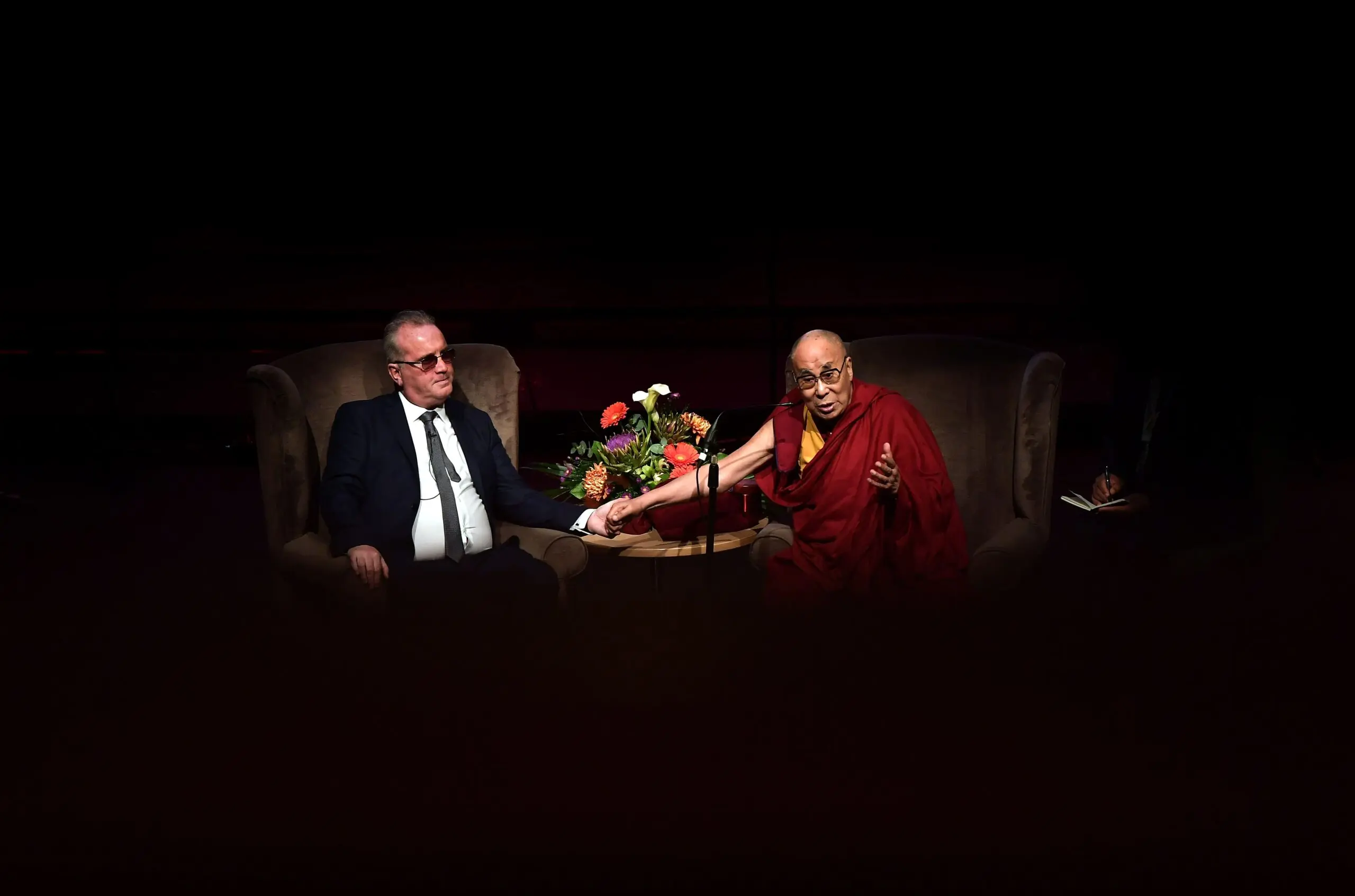 The Dalai Lama holds Richard Moore's hand as he gives a talk about compassion to celebrate 20 years of Moore's Children in Crossfire initiative on September 10, 2017 in Derry, Northern Ireland.