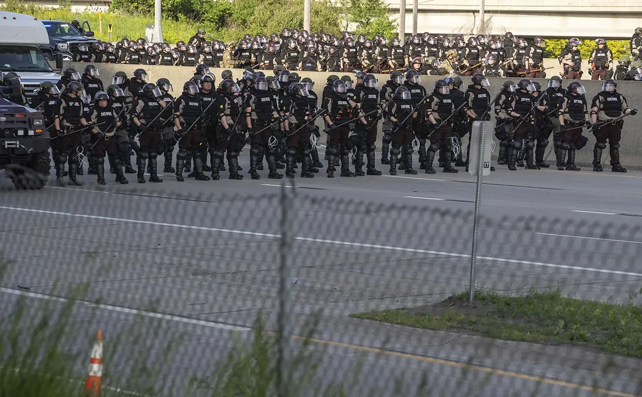 Hundreds of police officers with riot gear arrive to secure the scene where a tanker truck driver attempted to ram thousands of protesters on Interstate 35W in Minneapolis on May 31, 2020.