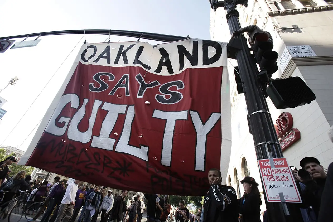Protesters unfurl a banner at the intersection of 14th Street and Broadway in Oakland during a protest over the verdict in the trial of a BART police officer who shot and killed Oscar Grant at the Fruitvale BART station on January 1, 2009.