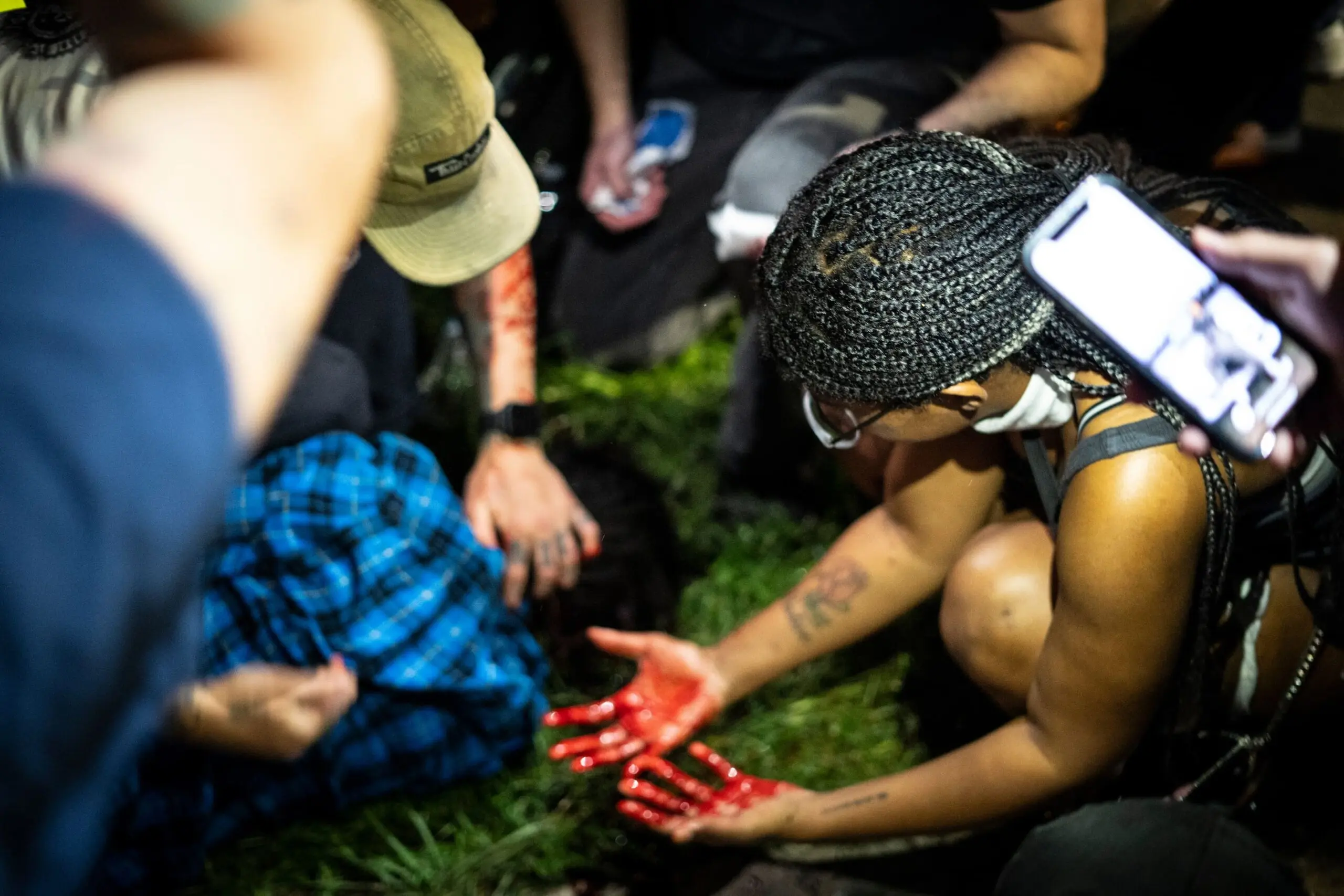 Street medics and protesters tend to Justin Howell moments after police shot them with bean-bag rounds.