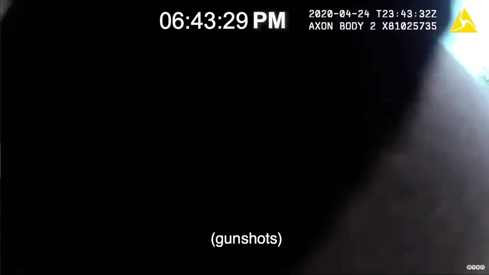 Closed-captioning saying "gunshots" displays over a darkened image that appears to be body-worn camera footage.