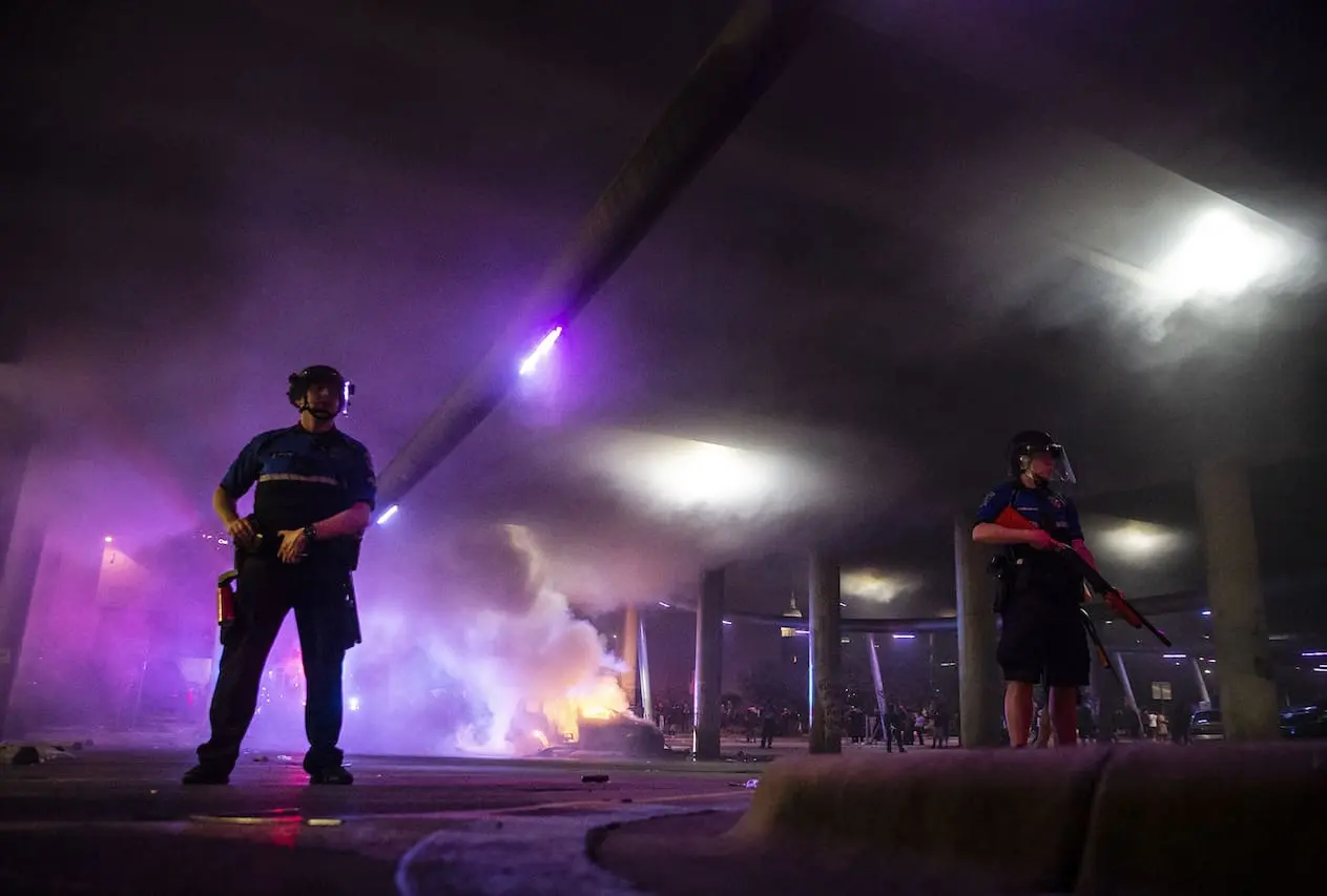 Austin Police officers stand guard as firefighters put out a car fire under I-35 freeway on Saturday, May 30, 2020.